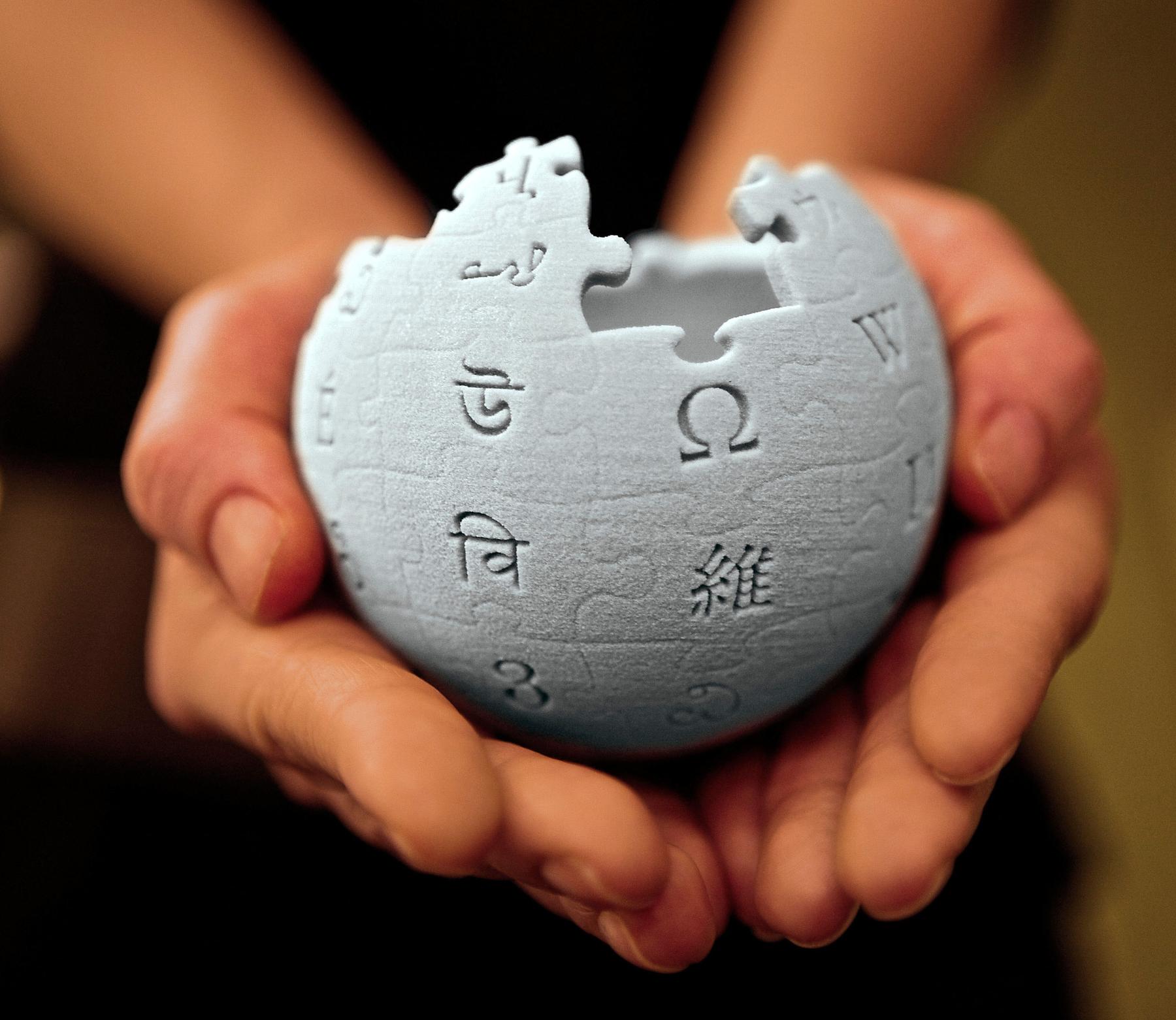 File:10 sharing book cover background.jpg - a person holding a piece of a puzzle