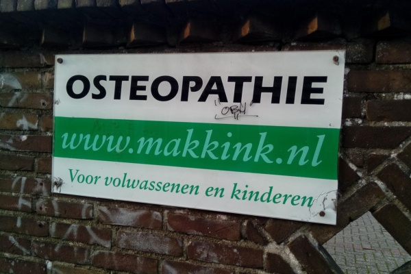 Osteopathie Makkink sign, Deventer (2019) - a sign on a brick wall that reads'go to the wumkren '