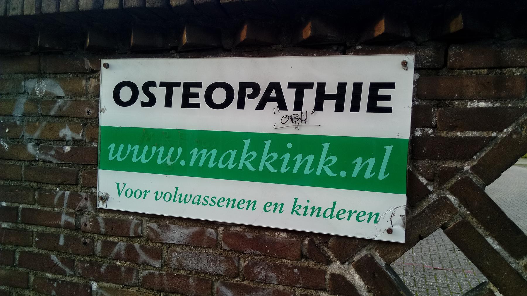 Osteopathie Makkink sign, Deventer (2019) - a sign on a brick wall that reads'go to the wumkren '